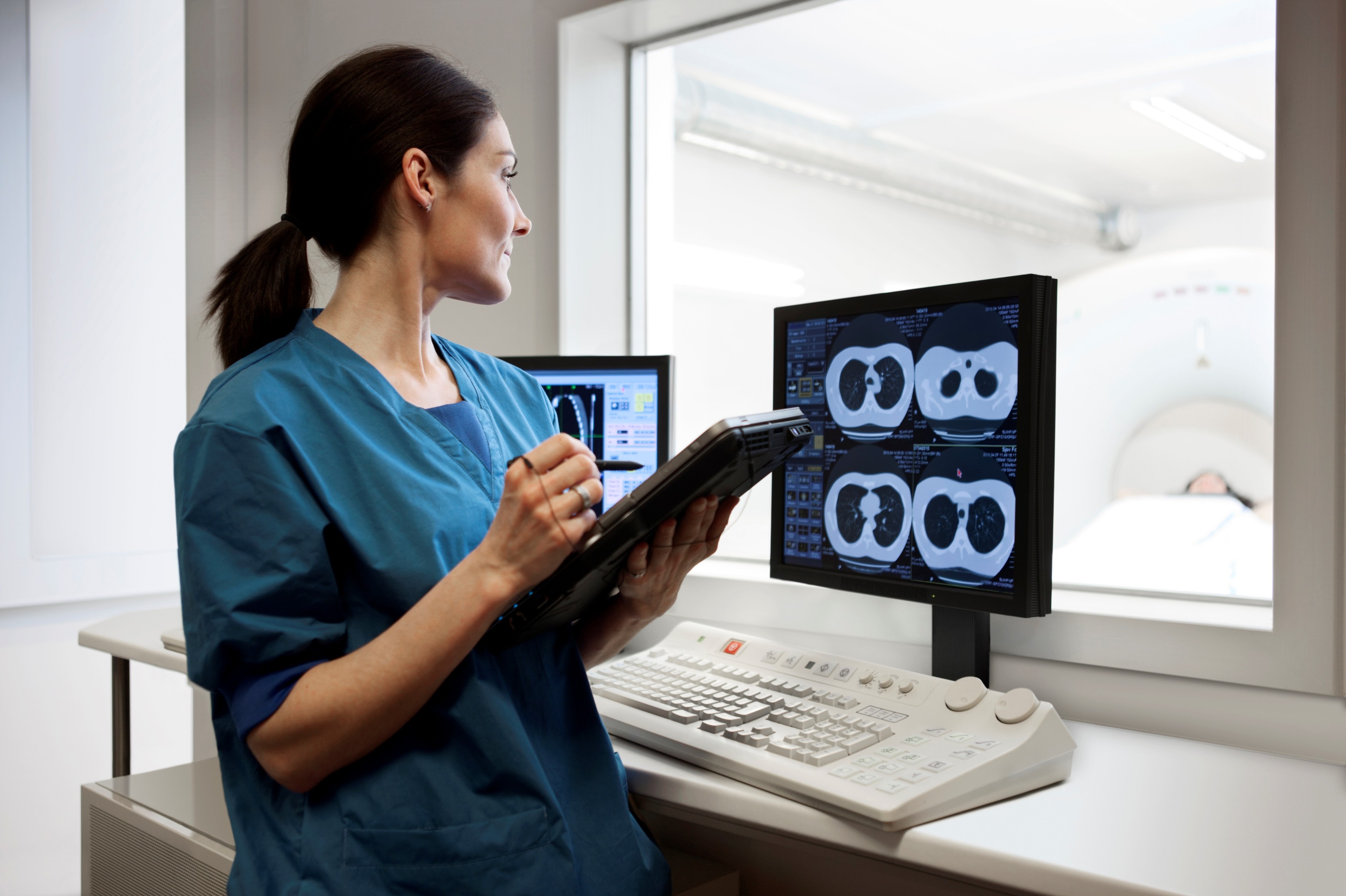 Radiographer reviewing CT images at a clinical workstation